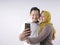 Happy Asian Muslim Couple, Taking Selfie Picture on Smart Phone