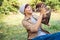 Happy Asian owner carrying, hugging Carrying adorable puppy dog her sitting green grass