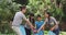 Happy asian parents and children holding sacks for plastic waste, making hand stack and cheering