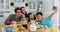 Happy asian parents in kitchen having breakfast with son and daughter, son taking group selfie