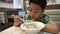 Happy asian preteens boy enjoy eating in morning breakfast