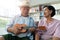 Happy Asian senior couple playing ukulele and singing together at home. The concept of life for the elderly after happy retirement