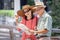 happy asian Senior couple tourists traveling looking at map and searching destination in urban city outdoors.  old man Travellers
