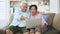 Happy Asian senior couple uses the laptop to find vacation destinations in the holiday season. Concept of happy elderly lifestyle