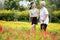 Happy asian senior grandmother and granddaughter walking in blooming garden,simple stress reduction,enjoying nature,smiling child