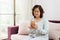 Happy Asian senior woman sitting on sofa and using a smart phone