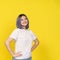 Happy Asian Teenager Girl, Dressed In White Shirt, Isolated Portrait On Yellow Background. Teenage Life, With Girl's