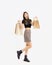 happy asian woman in black crop top t-shirt striped skirt and ankle boots carrying brown paper shopping bags on white background,