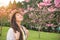 Happy asian woman enjoying smell pink flowers