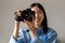 Happy Asian Woman Holding Camera Smiling Taking Photo Standing Indoors