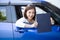 Happy Asian woman holding car insurance document book and sitting in car.