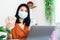 happy Asian woman holding Thai banknote and mobile phone make money online during self-quarantine at home