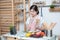 Happy asian woman looking recipe tablet kitchen reading cooking at home,University colleague student study online with social
