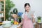 Happy asian woman looking recipe tablet kitchen reading cooking at home,University colleague student study online with social