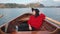 Happy asian woman relaxing in boat on the beautiful summer lake during her vacation. Pretty young girl sitting in boat