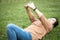 Happy asian woman resting feel comfortable while lying on the grass at park,female people stretching her clasped hands,enjoy