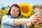 Happy asian woman selfy with sun flower in sunflower flower field.