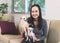 happy Asian woman sitting with two chihuahua dogs in living room  looking and smiling at camera. dog lover  stay home   social