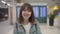 Happy Asian woman smiling to camera while staying at terminal in international airport, female tourist ready to travel on vacation