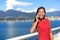 Happy asian woman talking on the phone in vancouver city harbour on summer day. Beautiful landscape of canadian nature