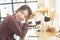 Happy asian woman teenager in casual dress face look at camera with big smile sit on table in coffee shop with smart mobile phone