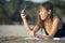 Happy Asian woman using mobile phone taking selfie portrait photo having fun relaxed