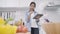 Happy asian woman using tablet for looking recipe while making food in the kitchen, female use organic vegetable for healthy food.