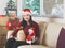 Happy Asian woman wearing Christmas Santa hat sitting with two chihuahua dog wearing Christmas costume in living room  , the dogs