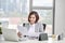 Happy asian woman working in office. Female going through some paperwork at work place