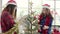 Happy Asian women holding xmas ornament for decorate christmas tree in her office.