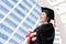 Happy Asian young beautiful graduate female student with University degree standing and holding diploma in hand after graduation