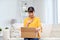 Happy asian young woman with parcel box at home