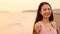 Happy asian young woman walking on the beach at sunset