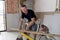 Happy attractive and confident constructor carpenter or builder man working and measuring wood in industrial construction job conc