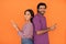 happy attractive hindu couple using cell phones on orange