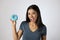 Happy attractive Latin woman smiling excited holding sugar donut on clear background in sugar abuse