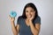 Happy attractive Latin woman smiling excited holding sugar donut on clear background in sugar abuse