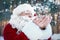 Happy Authentic Santa Claus blowing snow from his hands