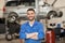 Happy auto mechanic man or smith at car workshop