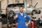 Happy auto mechanic man or smith at car workshop