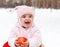 Happy baby with apple in winter park