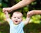 Happy baby boy learning to walk on grass