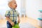 Happy baby boy playing with ride-on toy at home