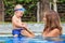 Happy baby boy swim with beautiful mother in pool