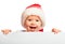 Happy baby in a Christmas hat and a blank billboard isolated on