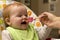 Happy Baby girl eating porridge