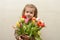 Happy baby girl rejoices and smiles with a bouquet of multi-colored tulips in hands