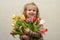 Happy baby girl rejoices and smiles with a bouquet of multi-colored tulips in hands