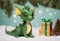 Happy baby green dragon is holding Christmas present. Generative AI