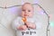 Happy baby with a lollipop on a white background with lights.